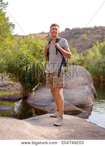 Overcoming the forest river. A man climbed out in the summer in the open air.