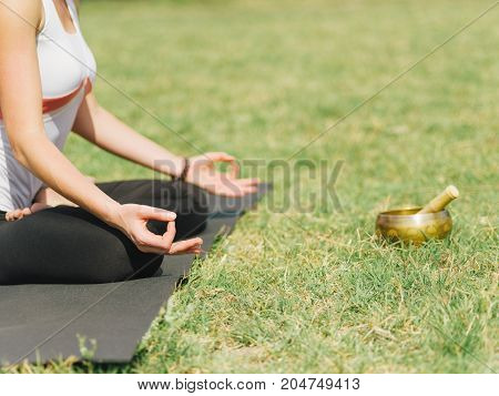 Close-up image of body parts girl's meditation at the health club outside with personal trainer, learning the correct form.