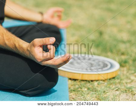 Close up of meditation athletic boy at the health club outside with personal trainer, learning the correct form.