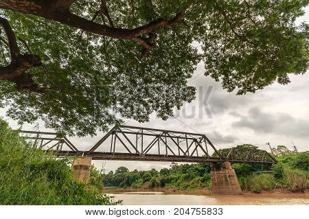 Iron railway bridge over the river in thailand.