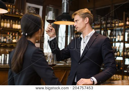 Man Sommelier Tasting Red Wine With Relax Emotion. The Man Is Holding  Wineglass And Smell. Man With