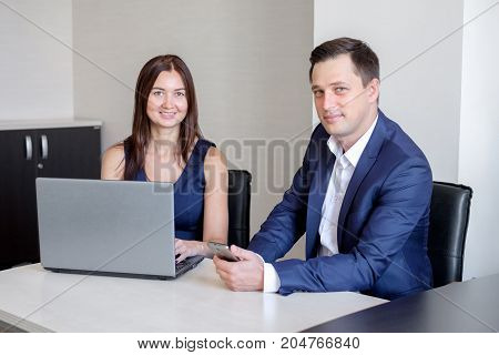 Business people discussing ideas at meeting using laptop in the office.