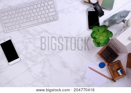 Mock up Smartphone with kayboard and office supplies on marble background