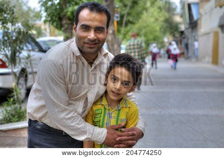 Fars Province Shiraz Iran - 18 april 2017: Family portrait of father and son on a city street man and boy posing for a photographer.