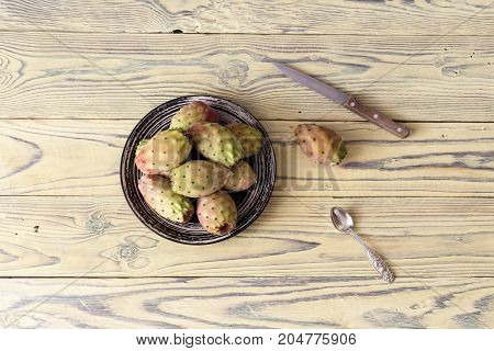 Edible cactus fruits opuntia on a plate close-up on a wooden table