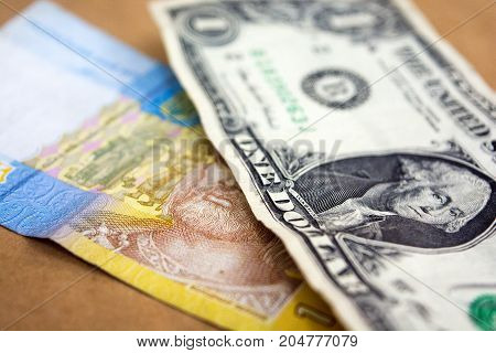 One Ukrainian Hryvnia and one US dollar. American and Ukrainian money.