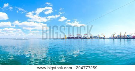 Panorama of the sea port. Cranes and ships. Bulk carrier ship in the port on loading.