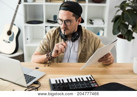 Thoughtful Musician Looking At Laptop