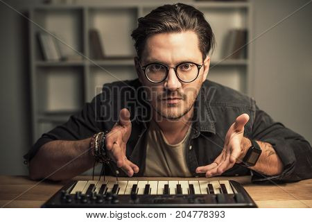 handsome young man in eyeglasses with keyboard controller