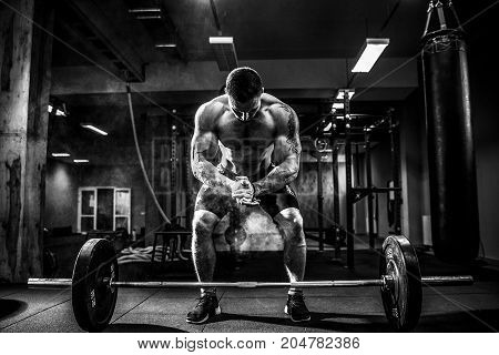 Muscular fitness man preparing to deadlift a barbell over his head in modern fitness center.Functional training.Snatch exercise