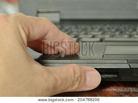 thumb pressing SD card put in computer notebook multimedia reader