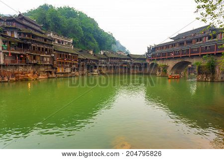 Riverside houses next to the Phoenix Hong or Huangsi Bridge in the center of traditional village of Fenghuang Hunan China