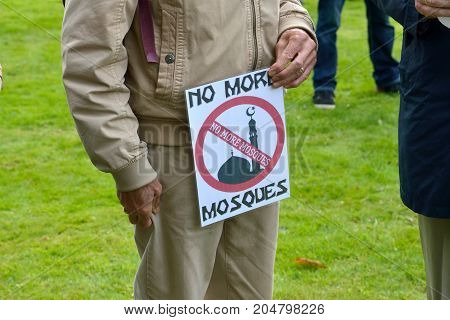 ENSCHEDE THE NETHERLANDS - SEPT 17 2017: An old man is holding a protest sign during an anti islam demonstration of Pegida. Pegida is a group of people who are against the islamization of Europe.