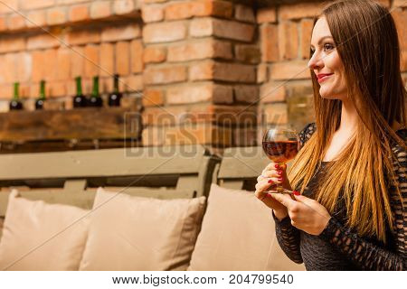 Woman Tasting Wine In Rural Cottage Interior