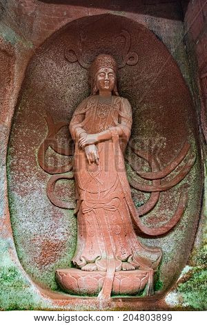 The Buddha statue in Leshan, China. The image of a woman in a rock in full growth