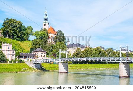 Salzburg Austria - August 3 2016: View of the Hllner church and quarter on the Salzach river bank