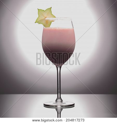 Milk Cocktail In Wineglass Decorated With Green Carambola On Studio Background.