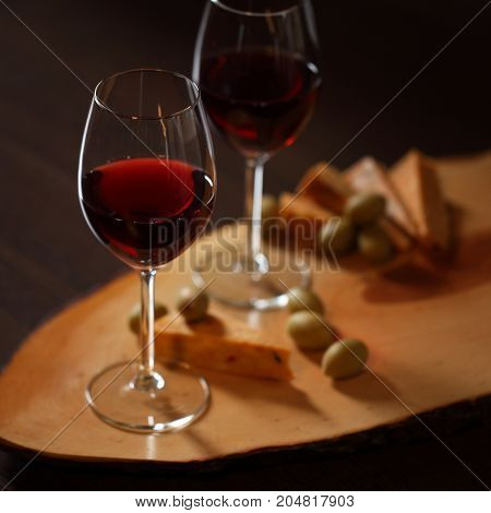 Wineglasses With Red Wine On Wood With Cheese And Green Olives - For Cozy Home Evening