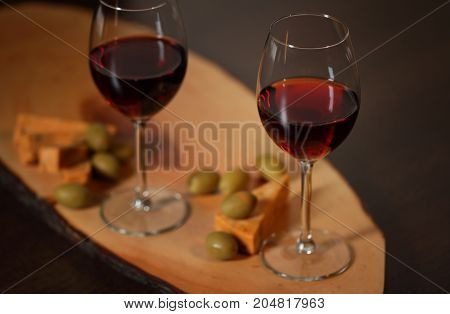 Wineglasses With Red Wine On Wood With Cheese And Green Olives - For Cozy Home Evening