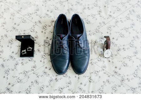 Groom's shoes and cufflinks, wristwatch on a light background. Wedding concept. Artwork, soft focus