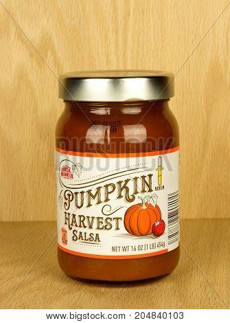 RIVER FALLS,WISCONSIN-SEPTEMBER 19,2017: A jar of Casa Mamita brand pumpkin salsa with a wood background.