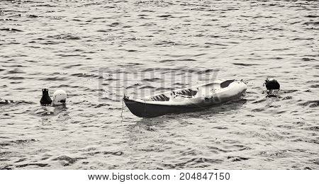 Anchored yellow kayak in Maslinica Solta island Croatia. Summer vacation destination. Black and white photo.