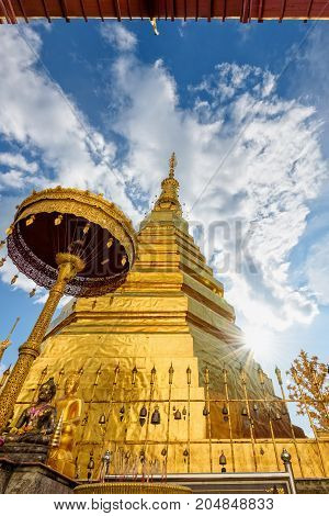 Wat Phra That Cho Hae Buddhism Temple with golden pagoda on blue sky background. Places worship of buddhists and attractions famous religion at Phrae Province Thailand