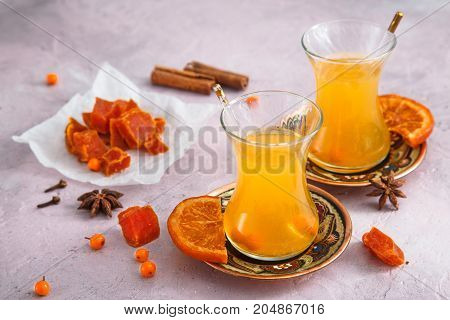 Small glasses of autumn yellow tea with swets and honey.