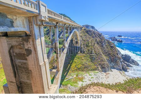 California travel concept. Iconic Bixby Creek Bridge on Pacific Coast Highway 1. Bixby Bridge is located near collapsed Pfeiffer Canyon Bridge in Big Sur.Popular landmark in California, United States.