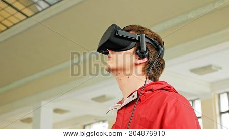 Teenager in VR headset enjoying virtual reality digital game. Virtual and augmented reality are increasingly used in human lives.