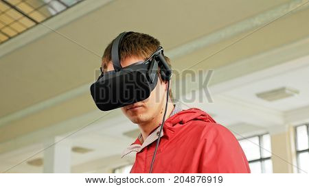 Teenager in VR headset enjoying virtual reality digital game. Virtual and augmented reality are increasingly used in human lives.