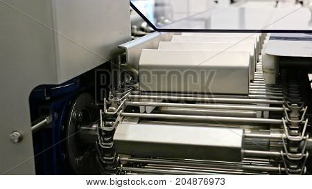 Food factory automated robotic machine. Conveyor product line for cooking and packing rations and food packs. Robotics and automatic lines used instead of human labor on factories and plants.