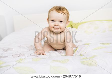 A Portrait of a crawling baby on the bed in her room
