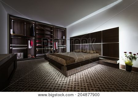 Interior design of dark toned bedroom in luxury apartment