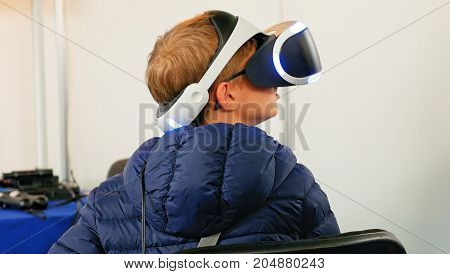 Child in VR headset enjoying virtual reality digital world. Virtual and augmented reality are increasingly used in human lives.