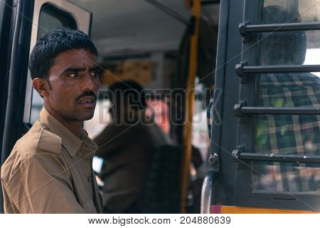 JAIPUR RAJASTHAN INDIA - MARCH 11 2016: Horizontal picture of indian black skin man looking from the bus in Jaipur known as pink city of Rajasthan in India.