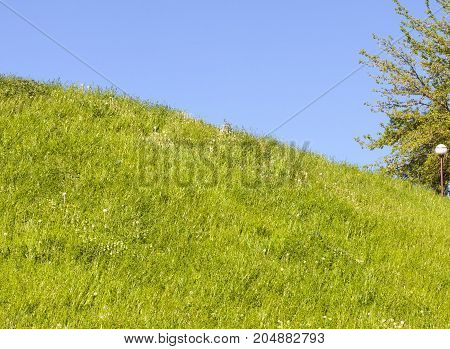 The Pillar On The Right And The Night Light On A Hill With Green Grass. Photo On The Background Of T