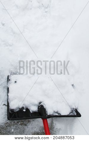 a snow shovel in the drive way.