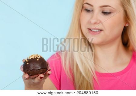 Woman Holding Chocolate Cupcake About To Bite