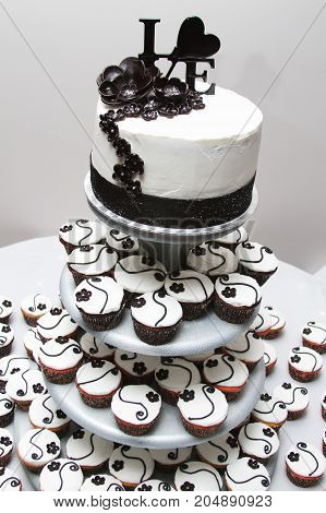 a white wedding cup cakes with love on top.