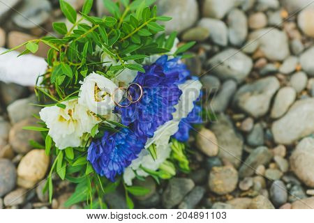 a Bridal bouquet lays on the rocks by the river