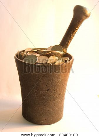 Munten en stamper in mortel