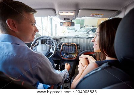 The beautiful couple chose a new car for themselves. The concept of buying a new car.
