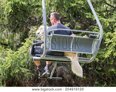 Ski Lift Chair In The Alps - Unrecognisable Man With A Dog
