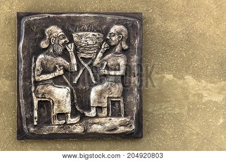 An ancient Mayan relief on bronze tablet with golden tones.