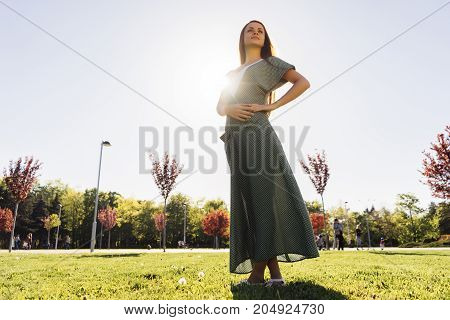 Full leight portrait of woman in dress in park