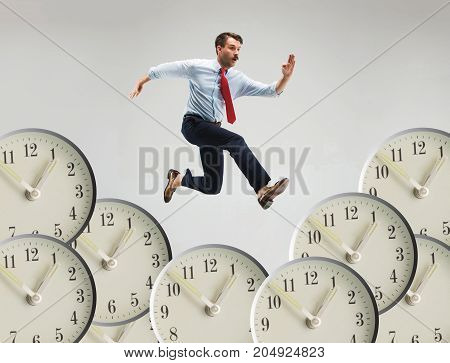Businessman running over alarm clock. Collage about tardiness and lack of time. concept of business acceleration