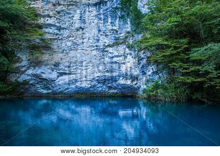 Amazing view of blue mountain lake like paradise, rock wall and colorful water .Scenery of Abkhazia paradise nature with awesome closeup perspective and fast stream.
