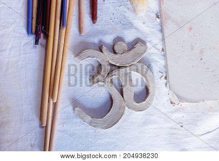 Symbol OM with clay on the desk