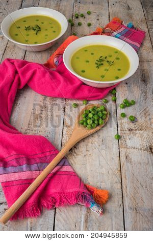 Fresh green pea soup with pea seeds. Cream soup of green peas. A delicious lunch in a rustic style